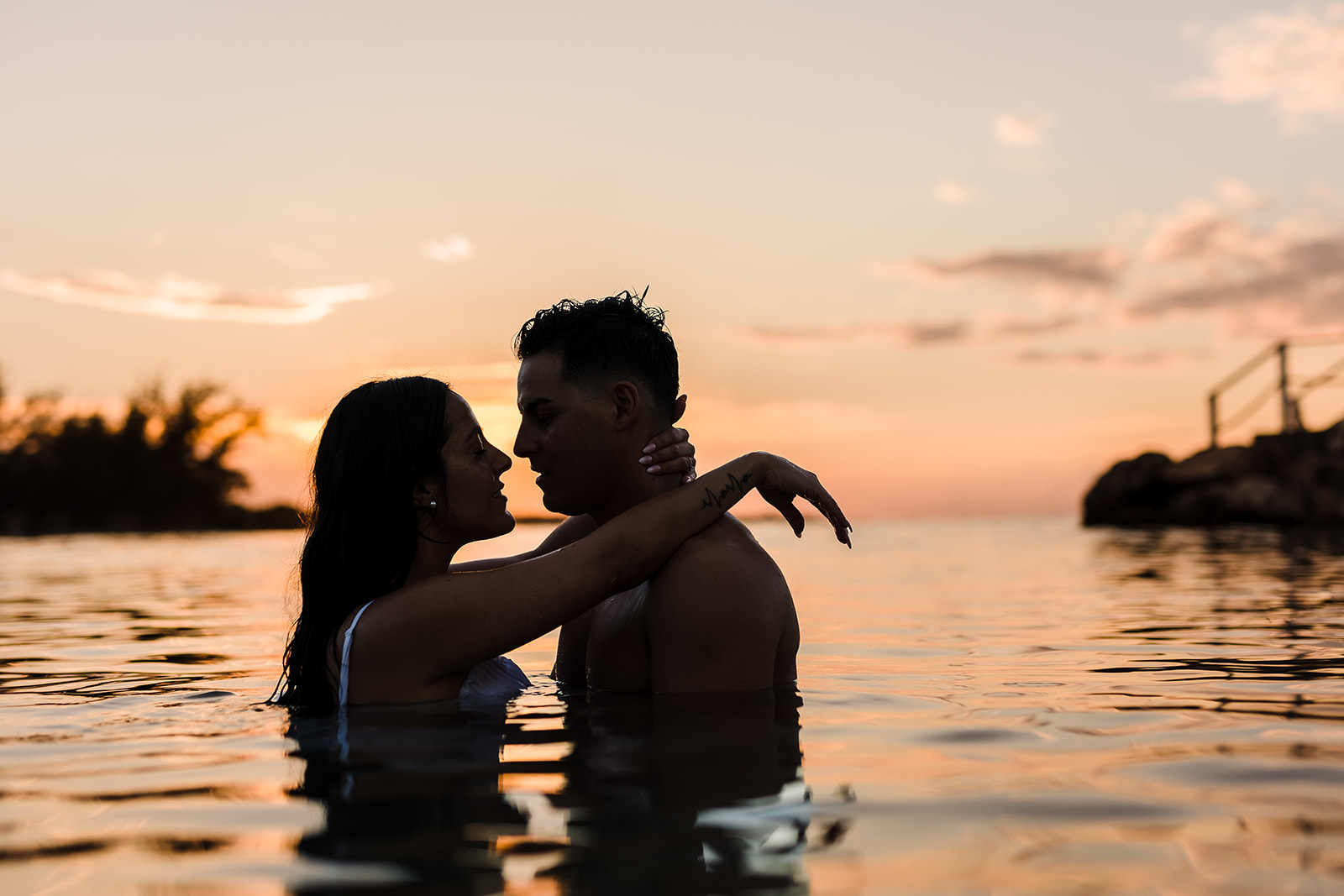 a couple almost kisses at sunset during their photo session with TKM photography, Roatan photographers