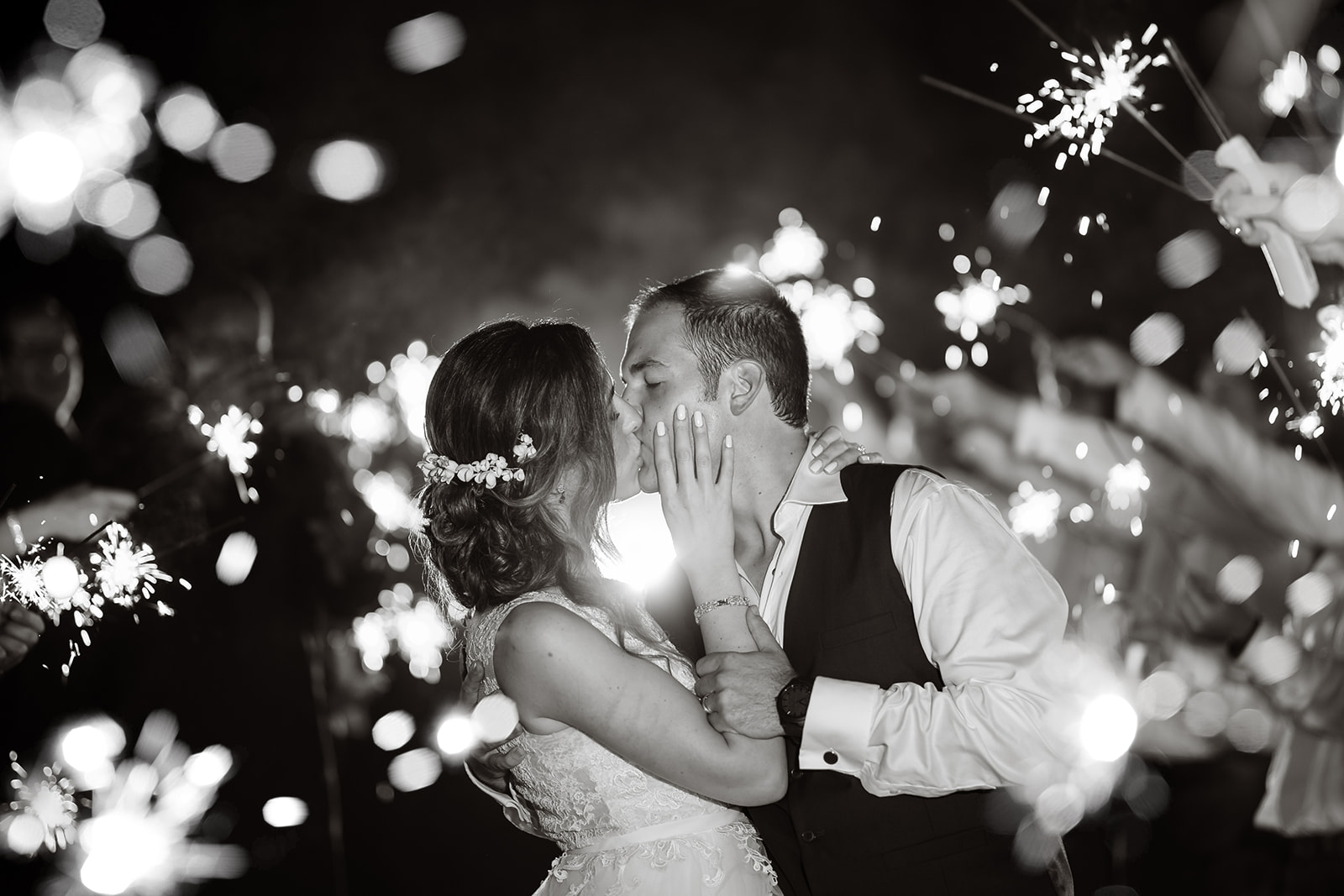 A couple kisses while in a sparkler tunnel at their Roatan wedding