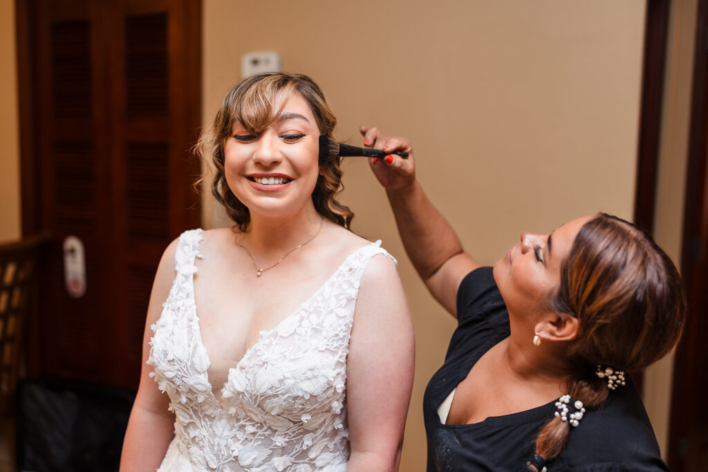 Ruth at Beauty Lounge Roatan, one of the best Roatan wedding vendors, is applying makeup to a bride on her wedding day 