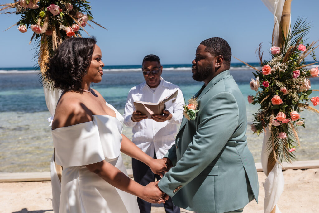 A couple at the alter on the beach getting married.
