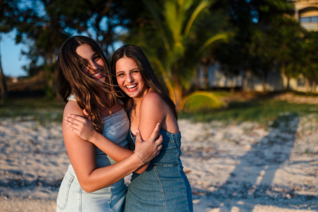 Sisters hugging on the beach.