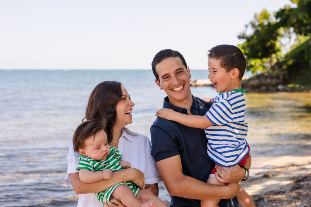 A young family smiling on the beach