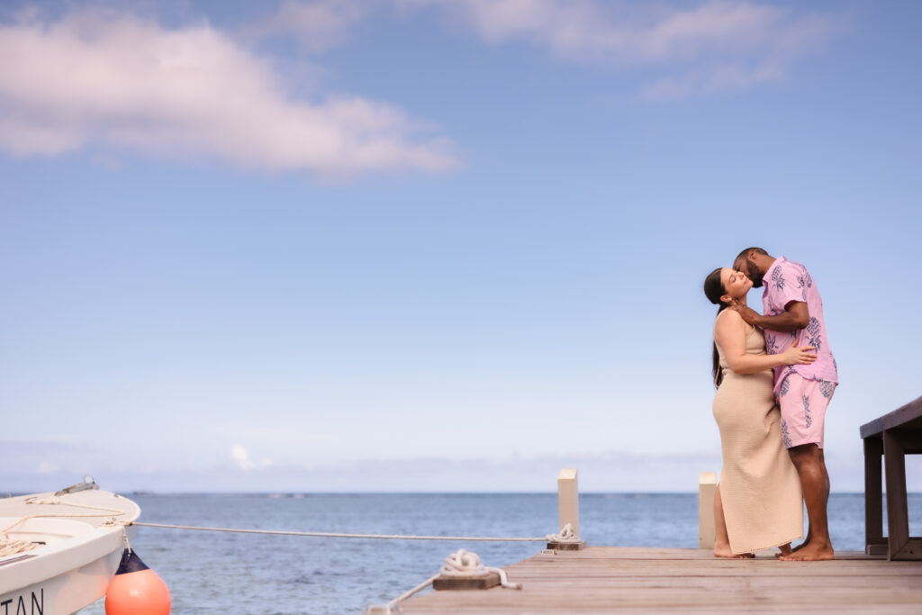 A man kissing a woman's next on the dock in roatan