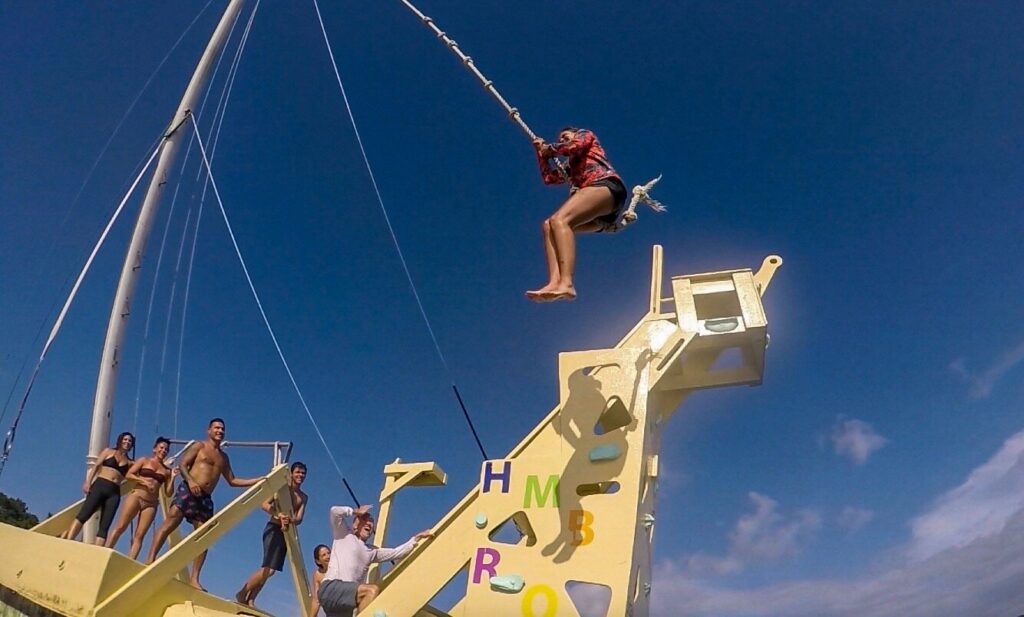 a person rope swinging into the ocean at iSoar.