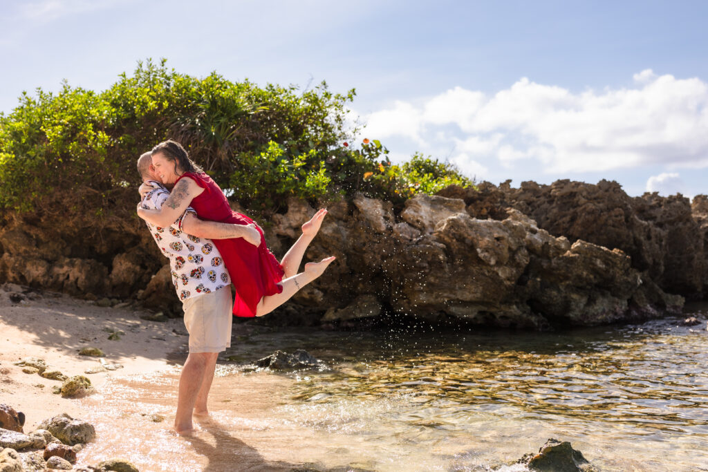 A couple hug on the beach in Roatan.