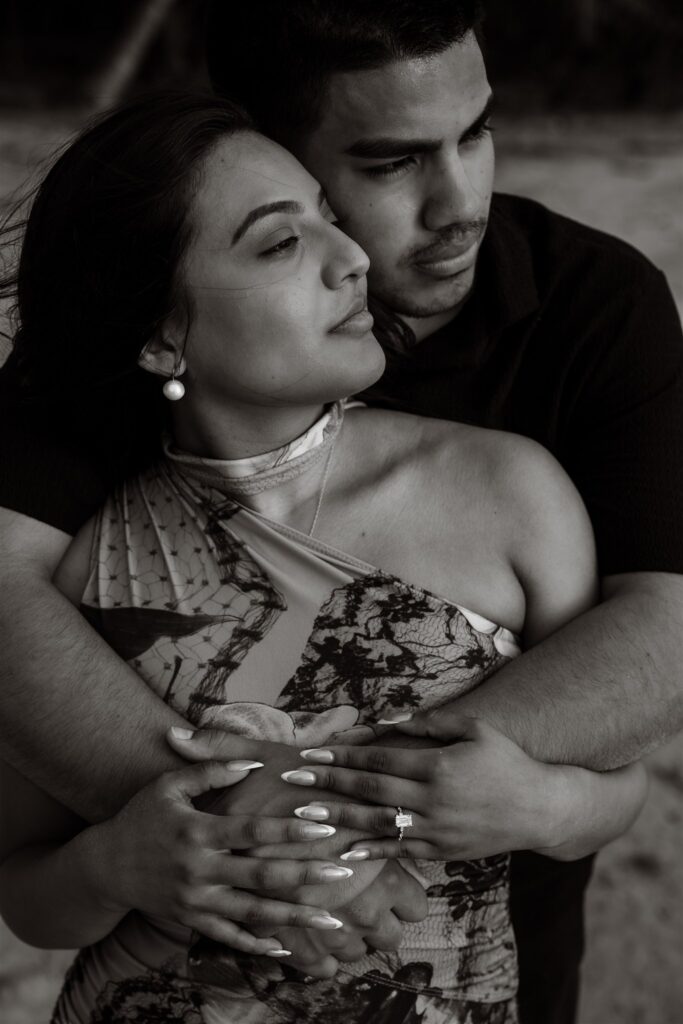 A couple embrace on a dock in Roatan after their Roatan proposal.