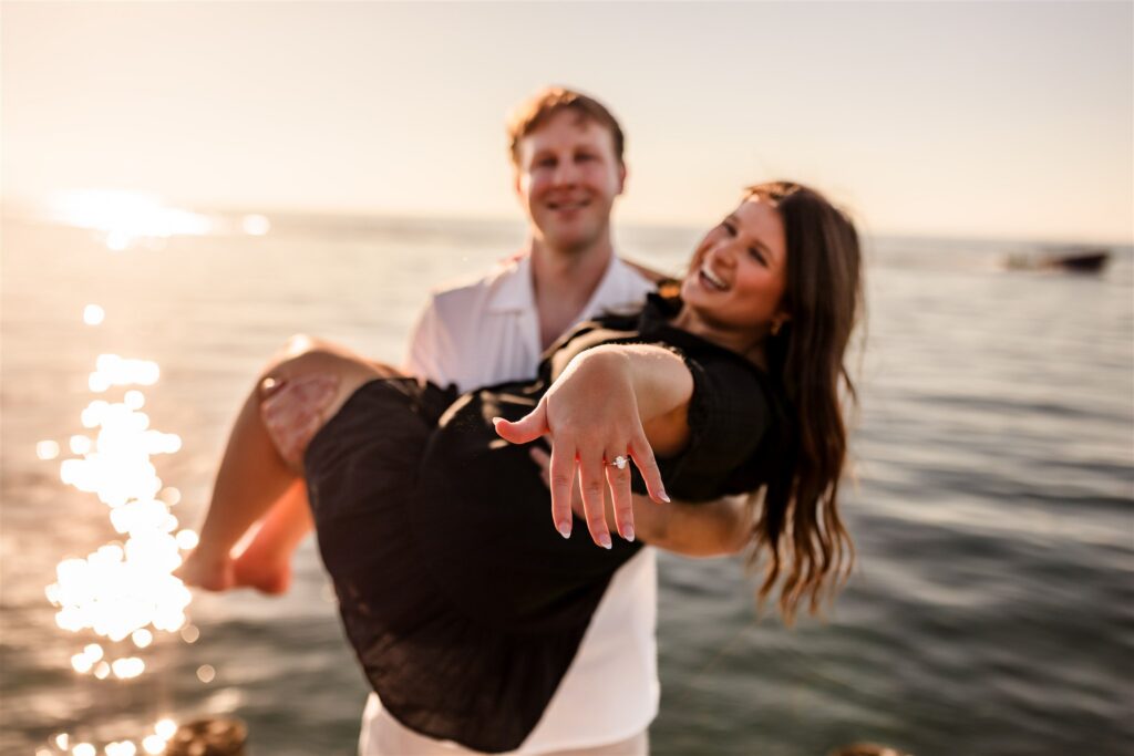 A bride-to-be shows off her engagement ring while being carried by her fiance in Roatan after their Roatan proposal.